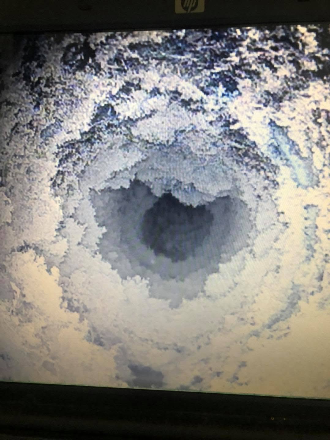 CCTV camera view looking up the inside of a flue, shown on a screen