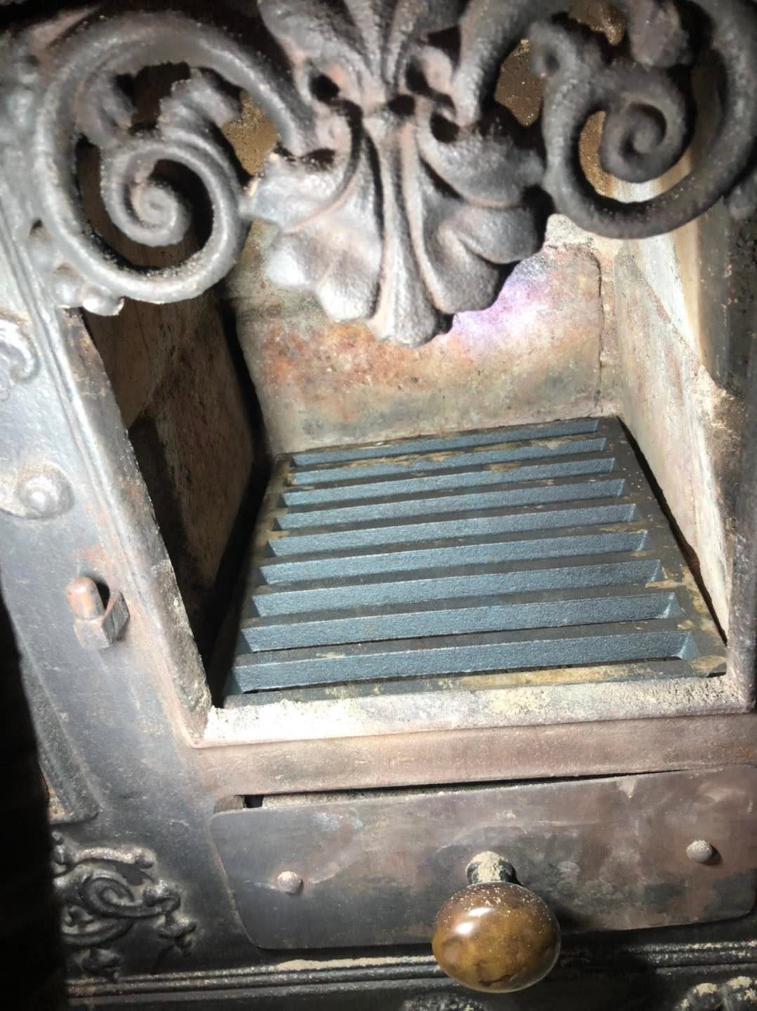 Ornate cast-iron stove interior with decorative scrollwork