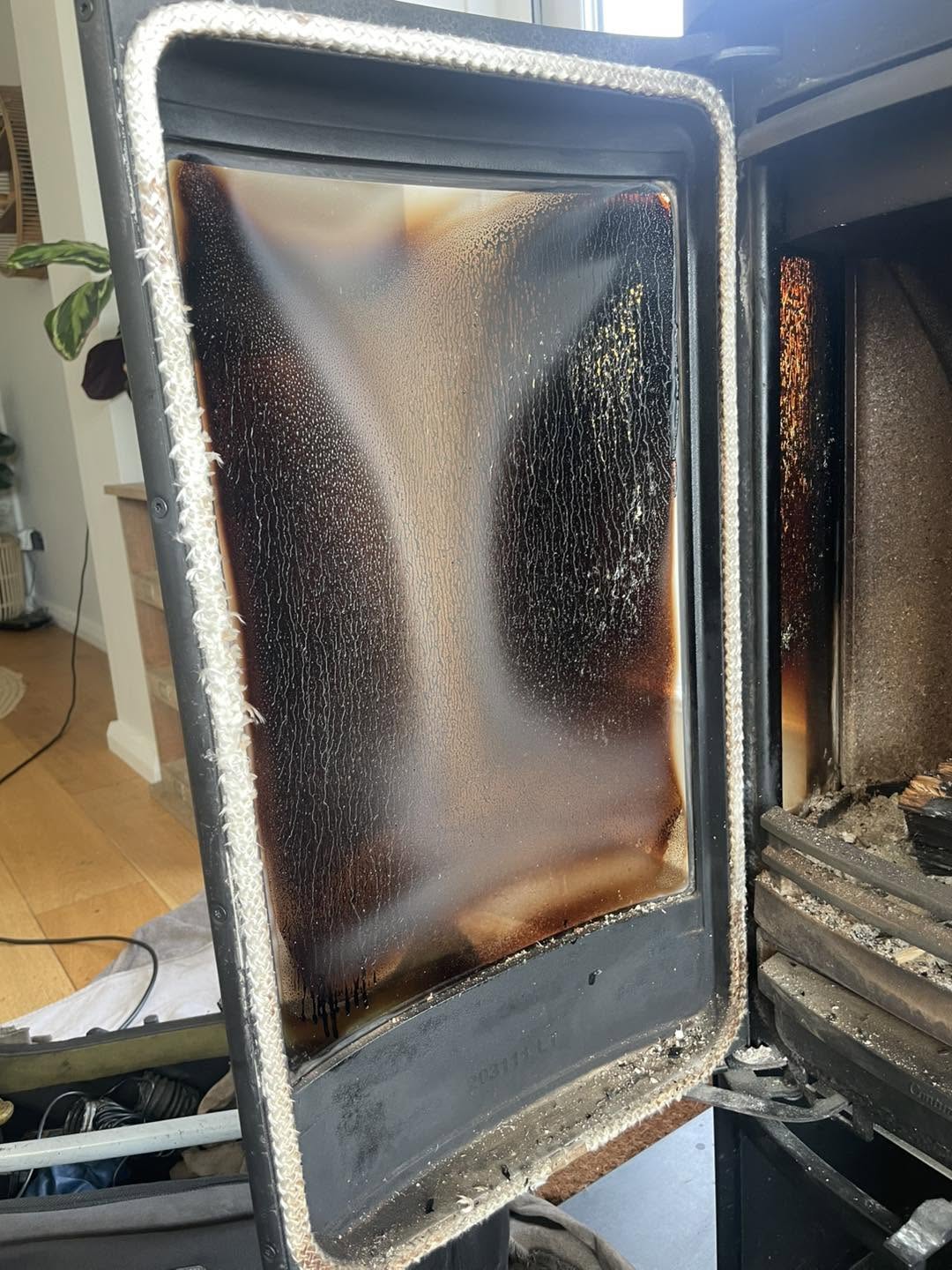 Stove door with its glass heavily stained by tar, before restoration