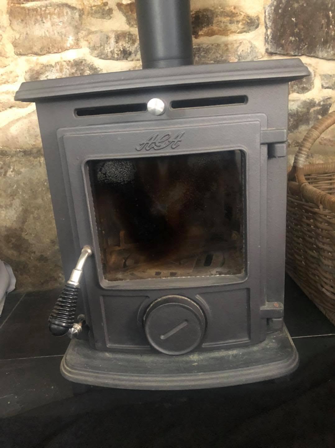 Small black cast-iron stove on a slate hearth