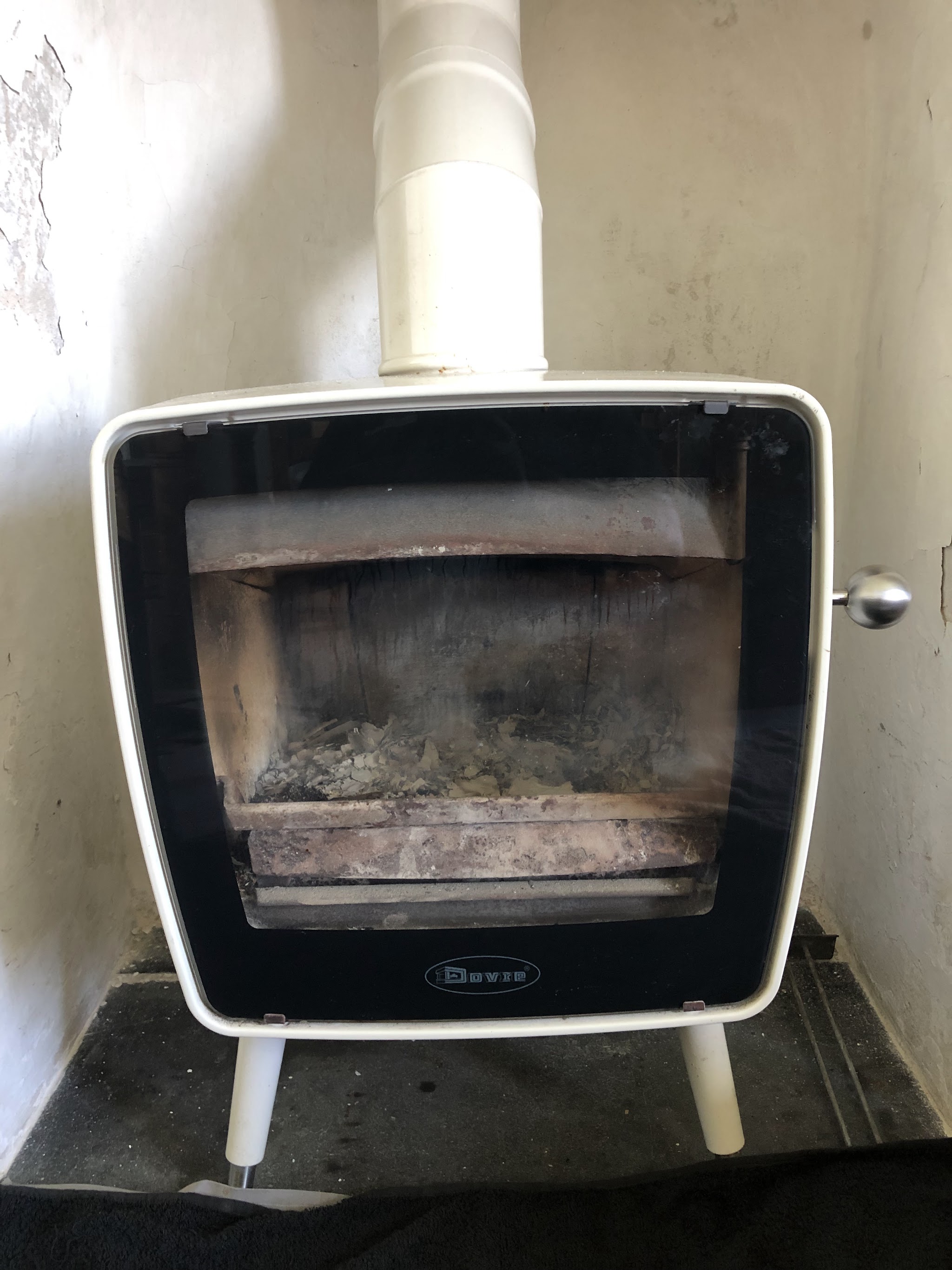 White retro stove on legs with a white flue pipe