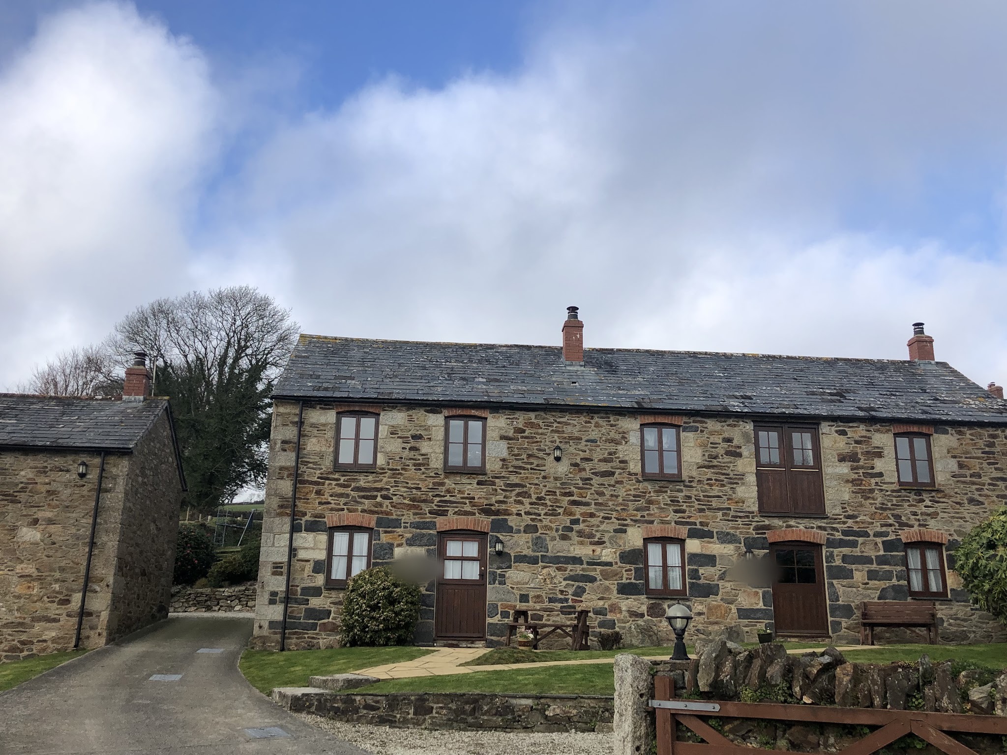 A row of Cornish stone cottages with chimney stacks and cowls